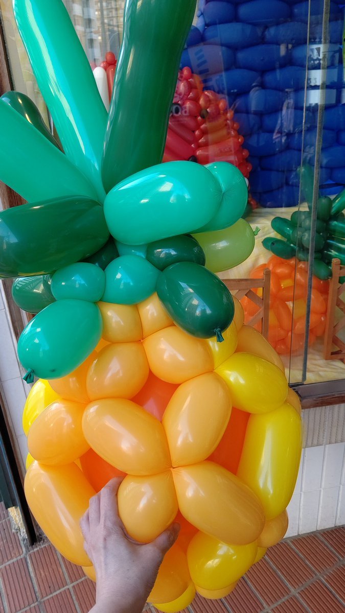 大きいパイナップル🍍を作った！ん？遠近法･･･あ、やっぱり大きかった！#バルーンアート #パイナップル #おもちゃの平野 [おもちゃの平野【Twitter】]
